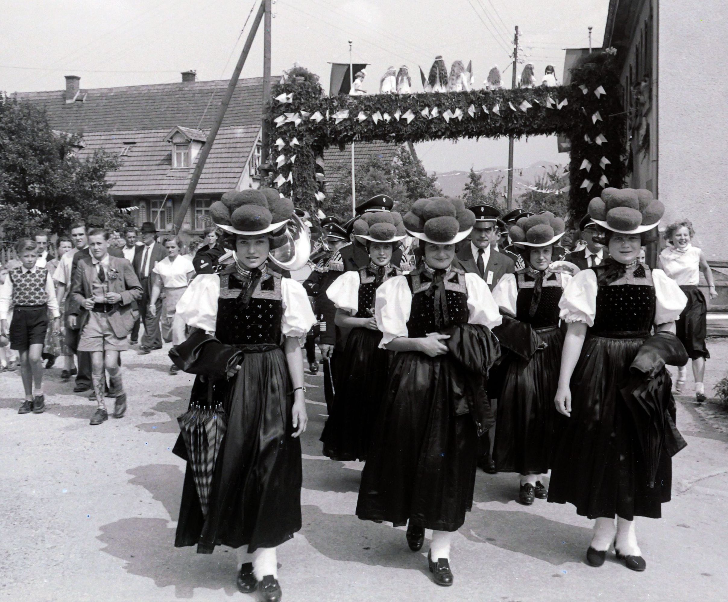 Die Bollenhut-Trachtenfrauen vor einem geschmückten Durchgang