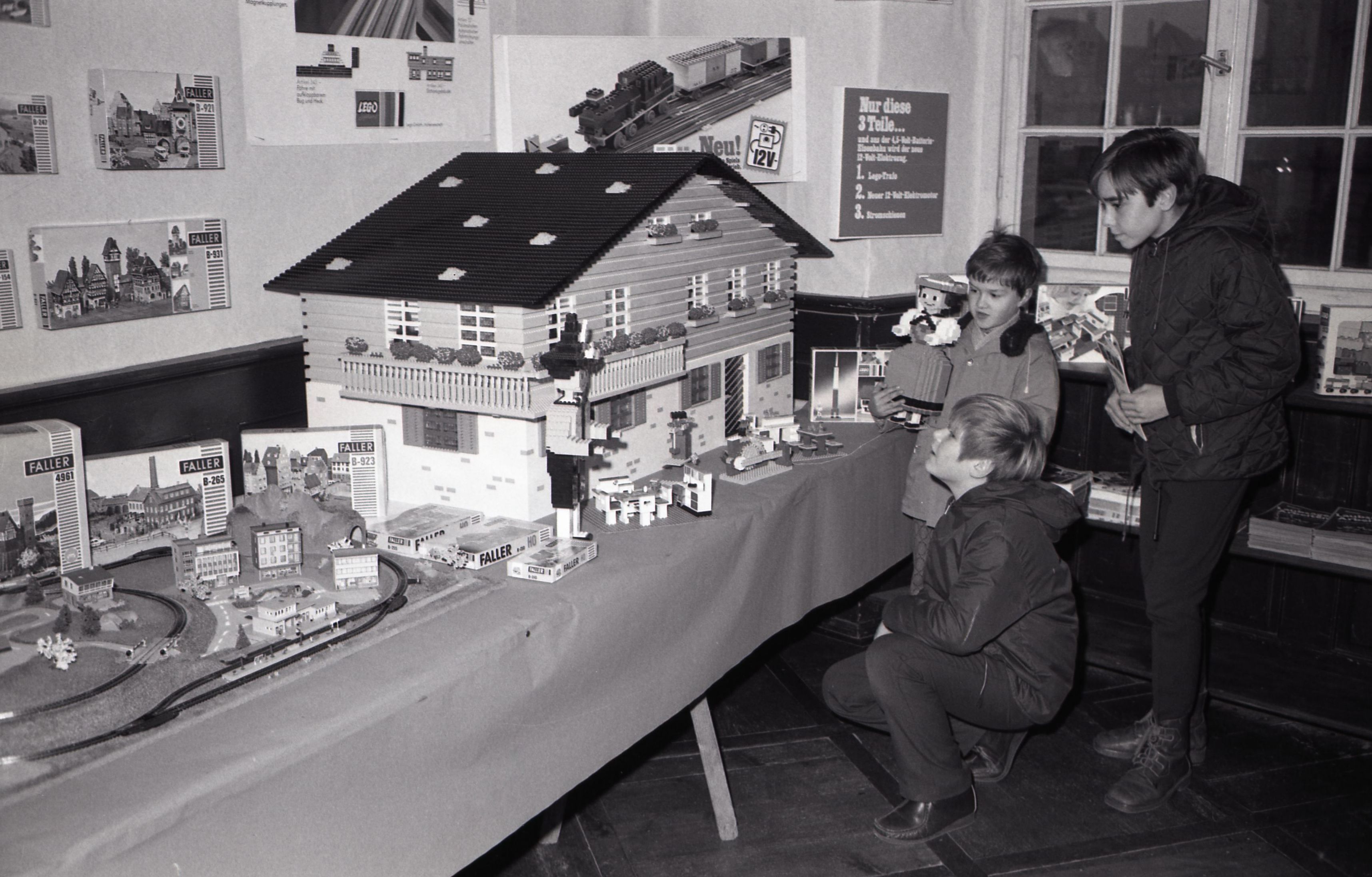 Spielzeugausstellung im Haus Löwenberg, Kinder bestaunen ein großes Spielzeughaus, Bilder von Friedrich Strohm